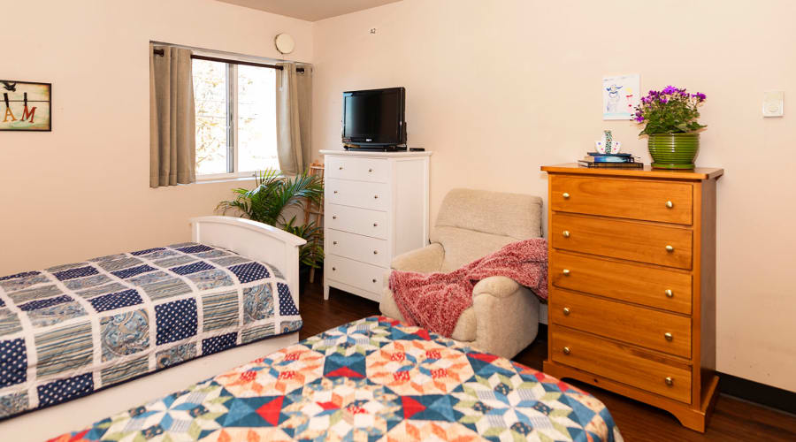Comfortably decorated private resident bedroom at Cascade Park Gardens Memory Care in Tacoma, Washington