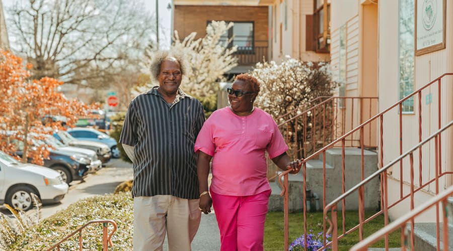 Resident and caregiver walking at 6th Ave Senior Living in Tacoma, Washington