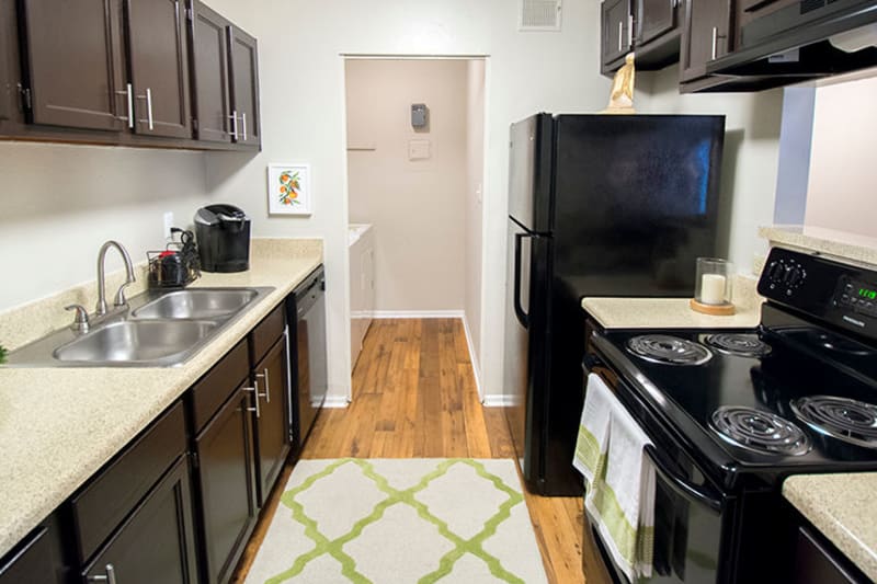 Modern kitchen with sleek black appliances in a model home's kitchen at The Everette at East Cobb in Marietta, Georgia