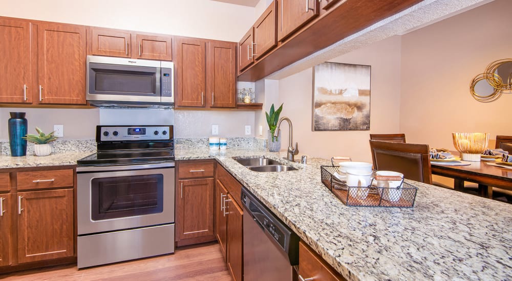 Granite countertops and white appliances in a kitchen at Ballantyne Apartments in Lewisville