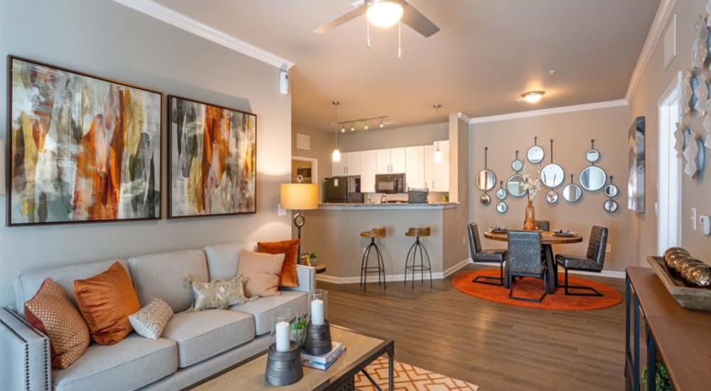 A furnished living room, dining room and bar seating in the kitchen at Lullwater at Blair Stone in Tallahassee, Florida