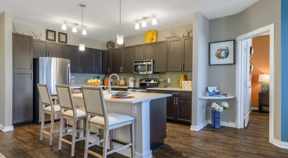 An open kitchen  with bar seating at an island at Liberty Mill in Germantown, Maryland