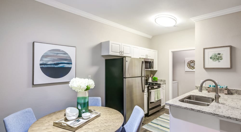 A dining area and open kitchen at Mode at Owings Mills in Owings Mills, Maryland