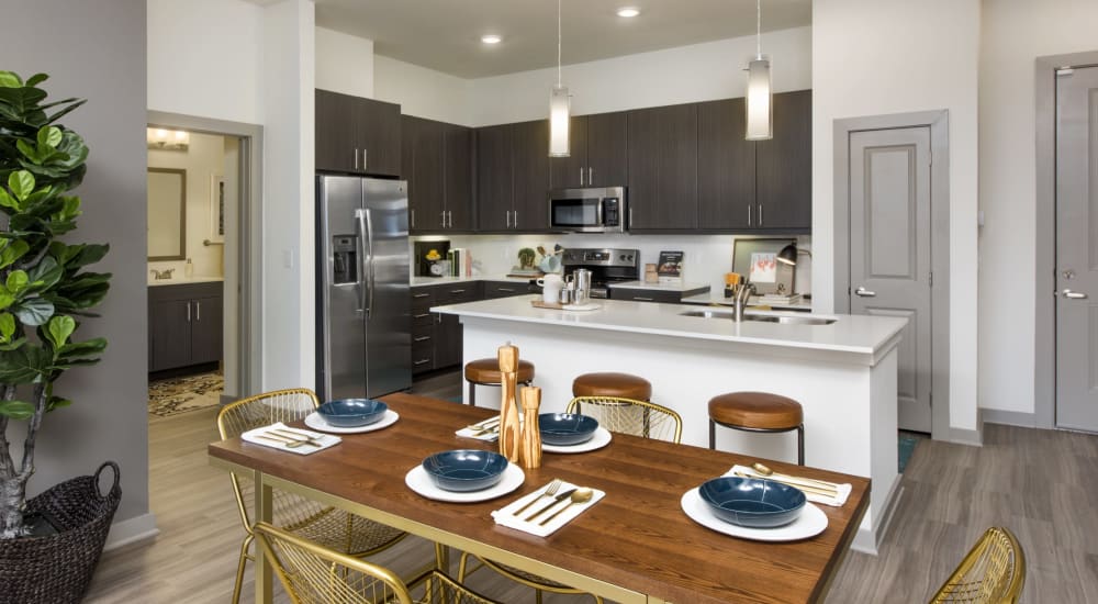 A set dining room table with a kitchen and island at Ravella at Town Center in Jacksonville, Florida