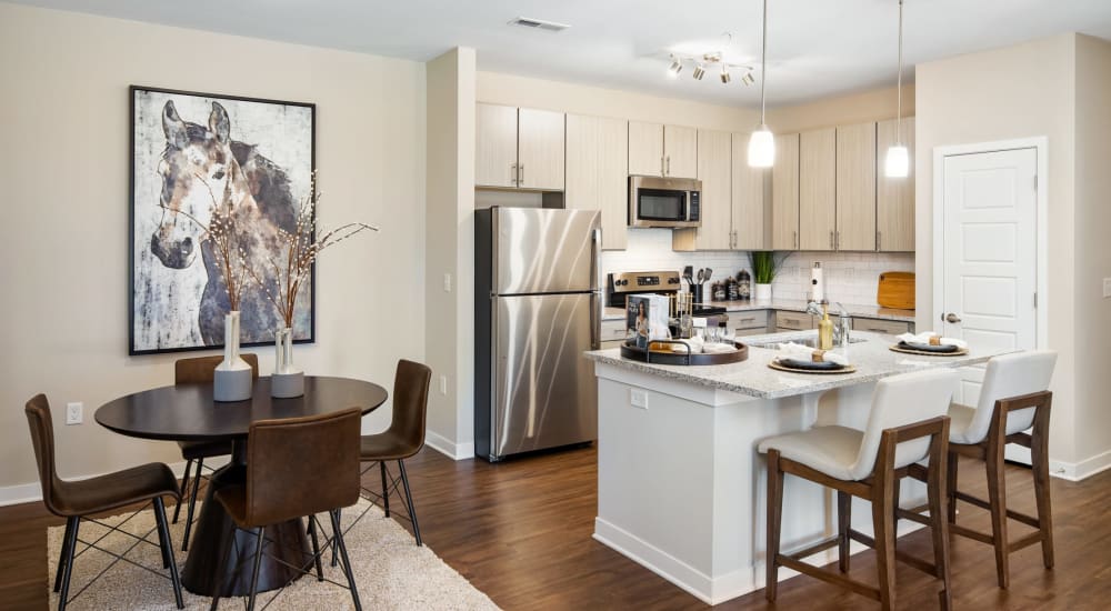 A dining area and kitchen with an island at The Alexandria in Madison, Alabama