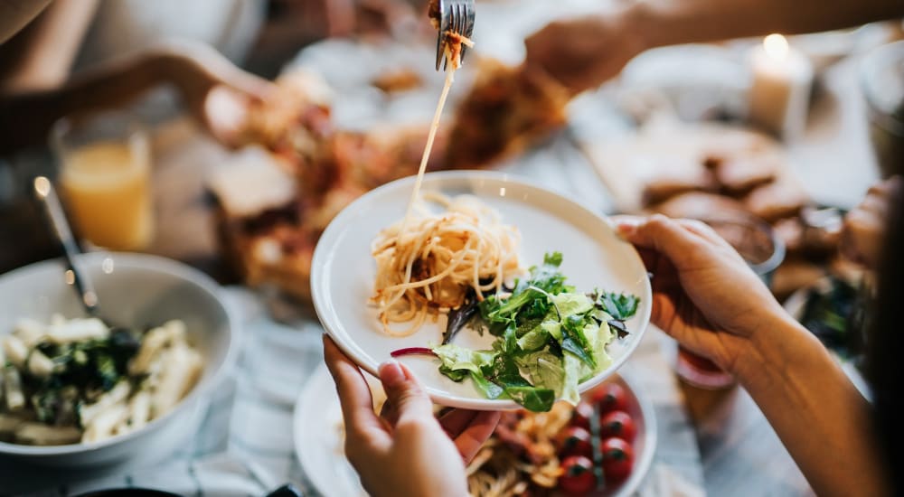 A group of people sharing food in a restaurant near Cypress McKinney Falls in Austin, Texas