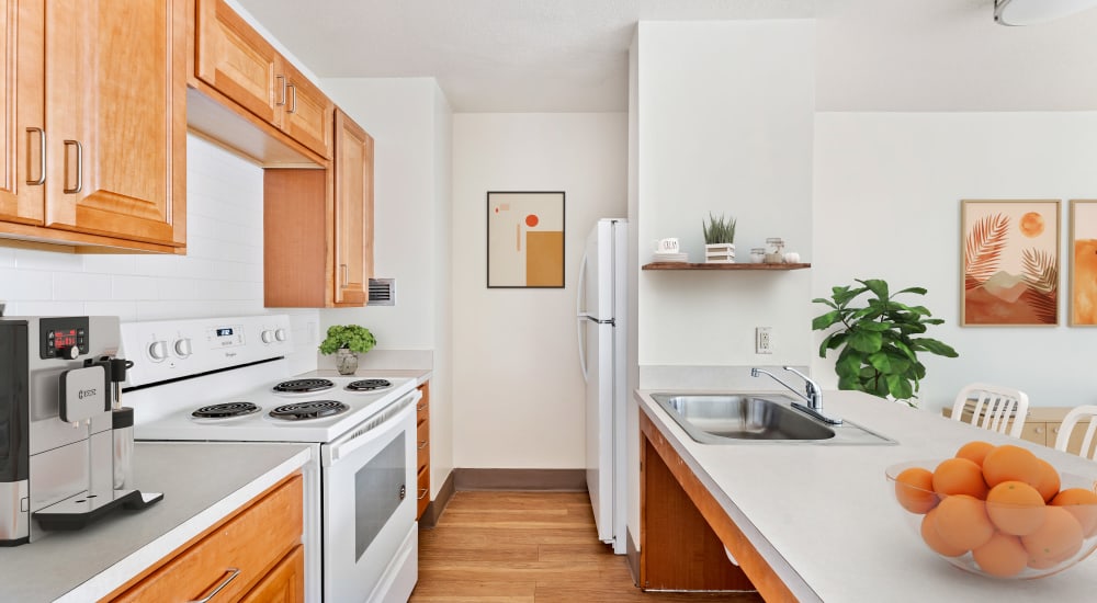 Fully equipped kitchen with natural wood cabinetry at Grace West Manor Apartments in Newark, New Jersey