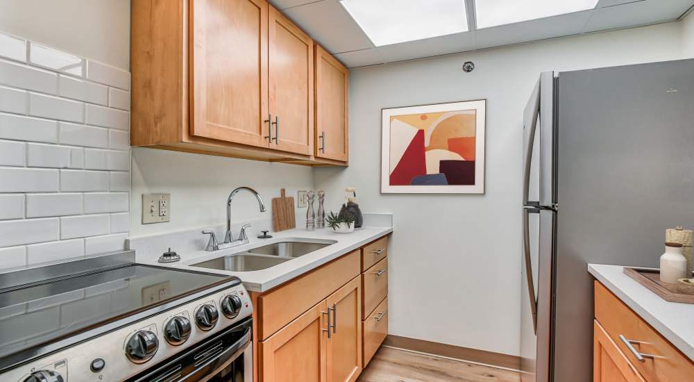 Fully equipped kitchen with natural wood cabinetry at Ashtabula Towers in Ashtabula, Ohio