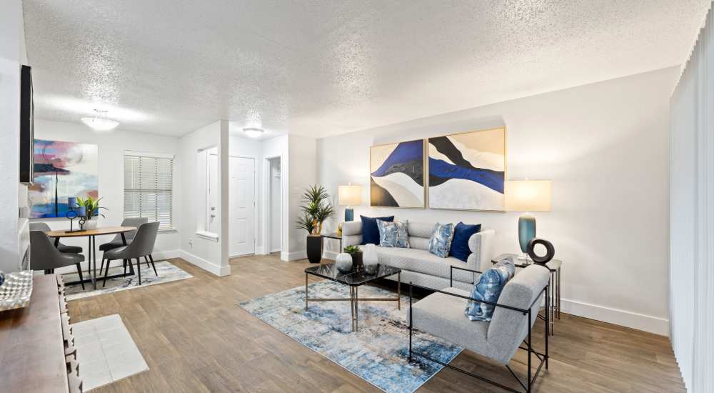Leather couch and a comfortable chair in a model home's living space at Admiral Apartments in Fort Worth, Texas 