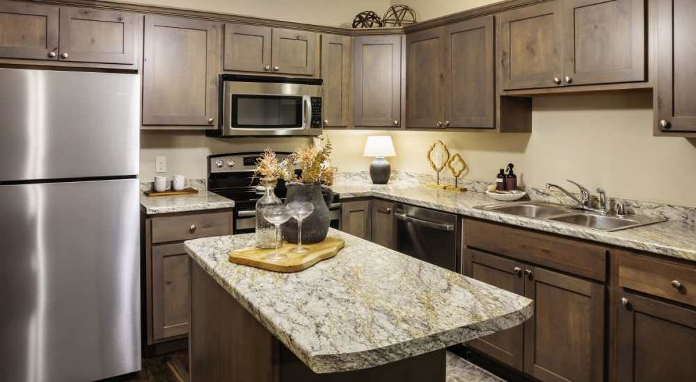 kitchen with wooden cabinets and stainless-steel appliances at InterUrban Apartments in Billings, Montana