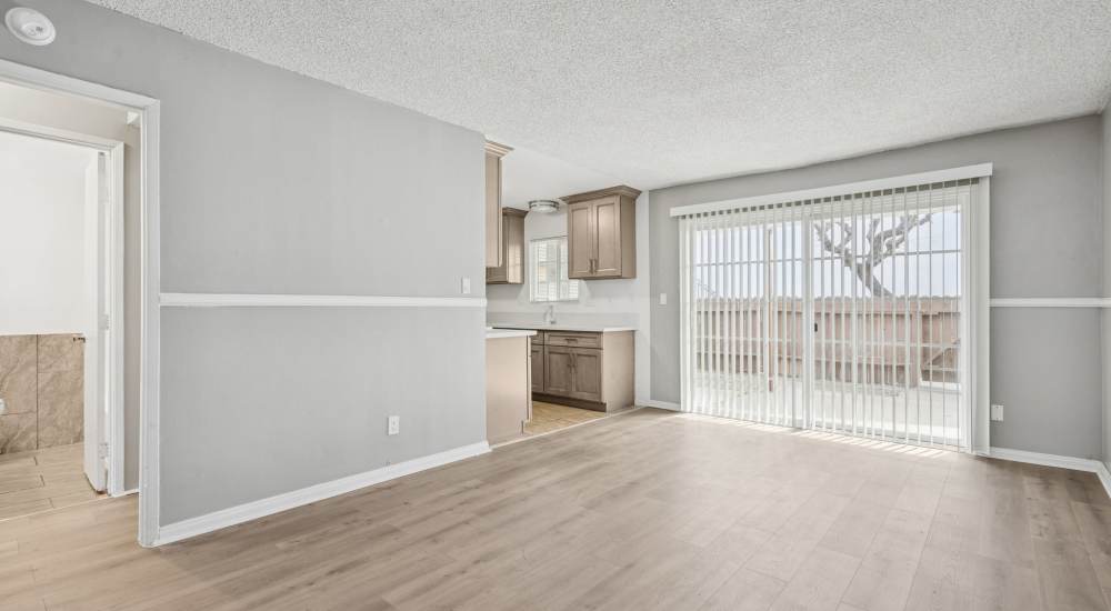 Apartment living room with view of kitchen and patio at Newland Garden Apartments in Garden Grove, California