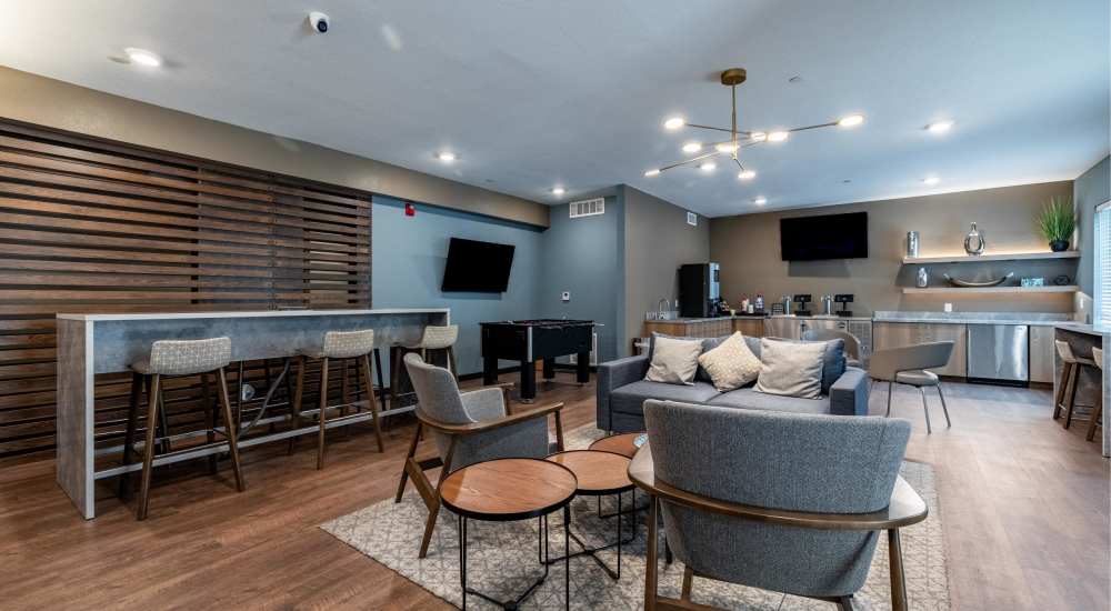 Clubhouse lounge living area with sofa and attached kitchen at WaterWalk Wichita - Downtown in Wichita, Kansas