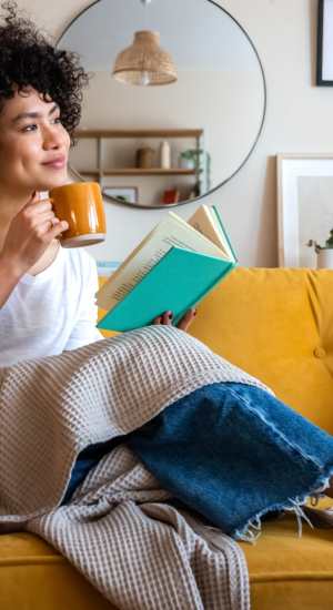 Resident drinking coffee in her living room at The Abbey at Medical Center in San Antonio, Texas  