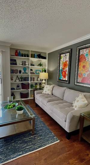 Living room with built-in bookshelf at The Abbey at Medical Center in San Antonio, Texas  