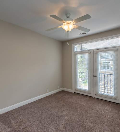 Empty room with beige walls and carpet at Red Knot at Edinburgh in Chesapeake, Virginia.