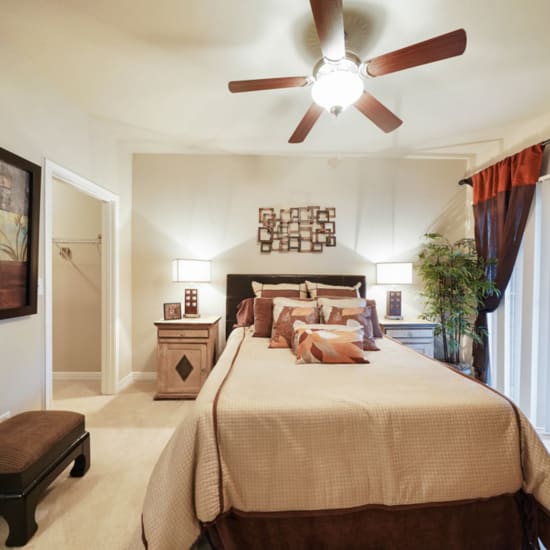 Bed and nightstand in a model home's bedroom at River Pointe in Conroe, Texas