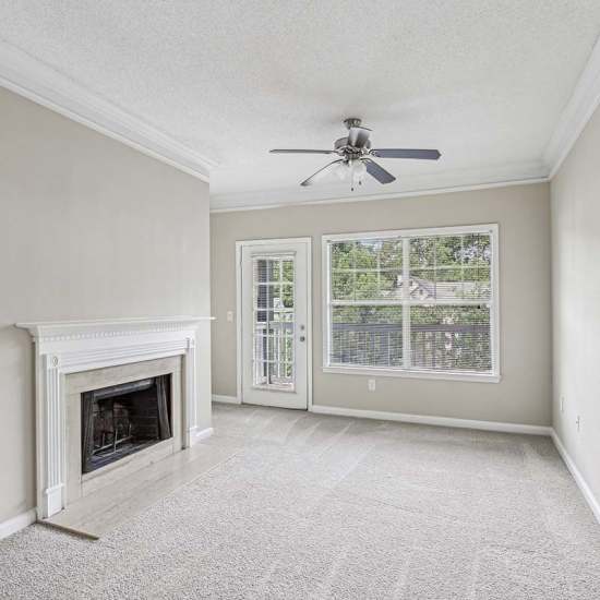 Unfurnished living room with fireplace at Grande Oaks in Roswell, Georgia