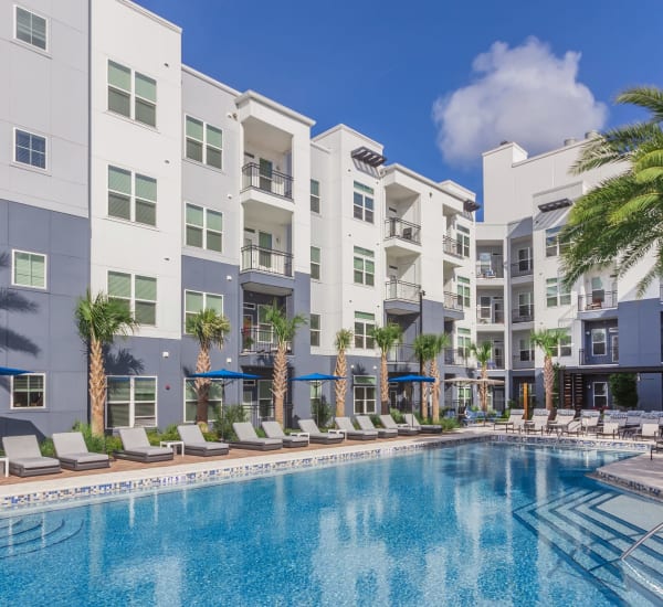 The resort-style swimming pool between apartment buildings at Ravella at Town Center in Jacksonville, Florida