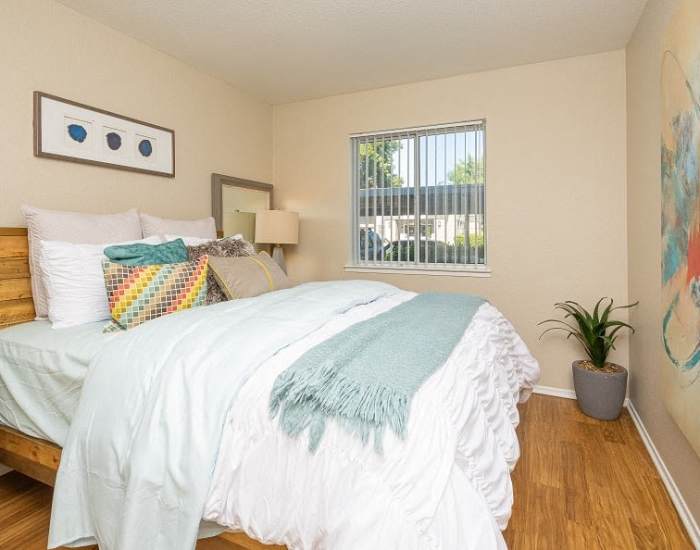 An apartment bedroom with wood-style flooring at Manchester Court in Modesto, California