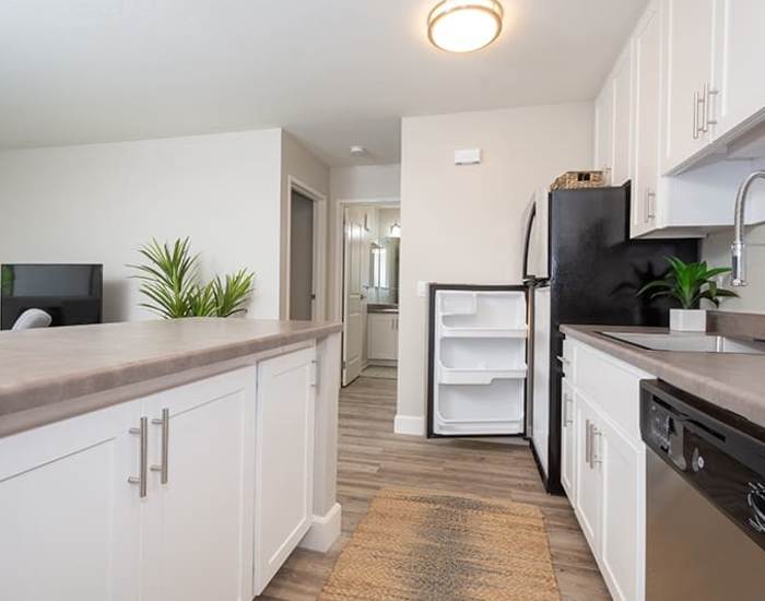 An apartment kitchen with wood-style flooring at Ellinwood in Pleasant Hill, California
