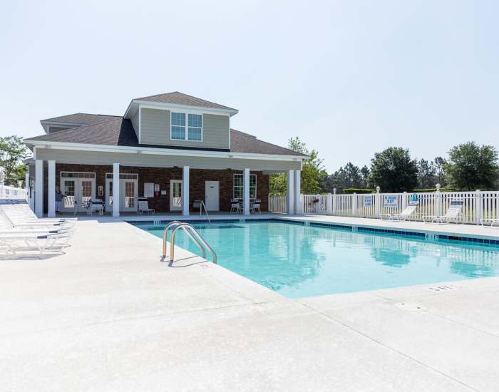 The community swimming pool surrounded by outdoor seating at Cloisters at Carolina Forest in Myrtle Beach, South Carolina