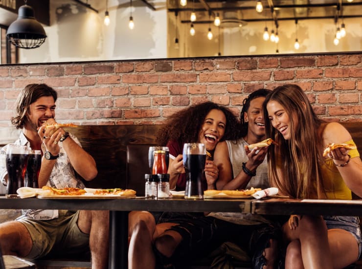 A group of friends laughing in a restaurant in the neighborhood near Palmetto Place in Miami, Florida