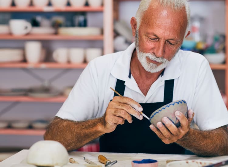 Resident working on a bowl in the pottery class at Riverwalk Pointe in Jupiter, Florida