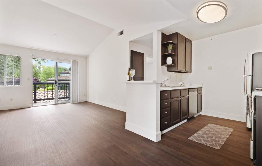 View of the kitchen and a door leading to the private balcony at La Vina Apartments in Livermore, California