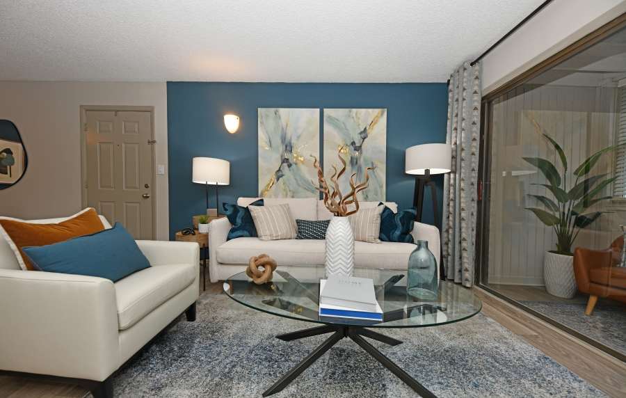 A couch, arm chair and glass coffee table in an apartment living room at Ascent Apartment Homes in Asheville, North Carolina