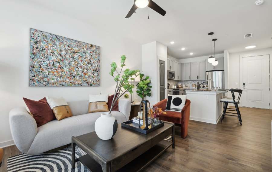Wood flooring and modern finished in an apartment kitchen and living room at The Southerly at Orange City in Orange City, Florida