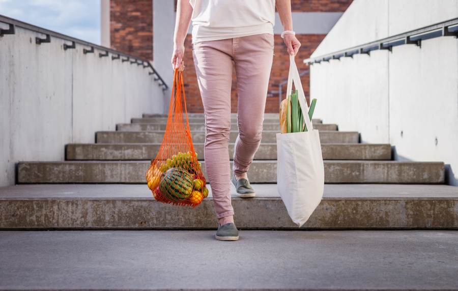 A resident carrying groceries outside near Ascent Apartment Homes in Asheville, North Carolina