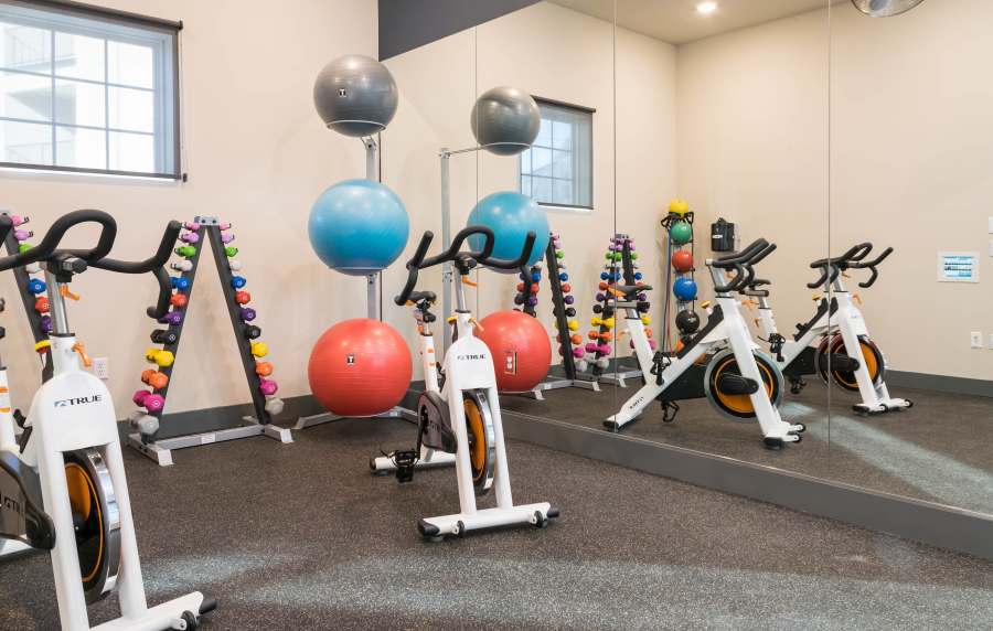 Fitness center with carpet flooring at Altair At The Preserve in O'Fallon, Missouri