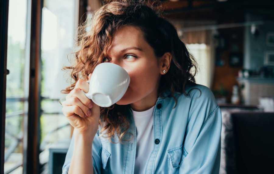 Woman having coffee at a cafe near Park Hacienda Apartments in Pleasanton,California