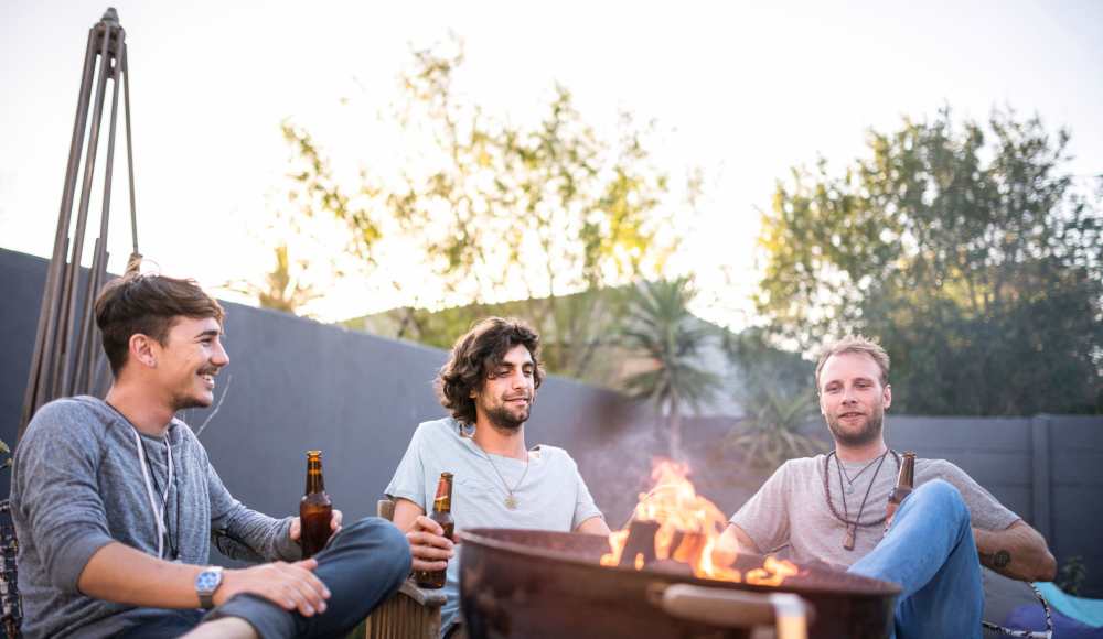 Friends hanging out around a firepit at Pittsford Village Estates in Pittsford, New York