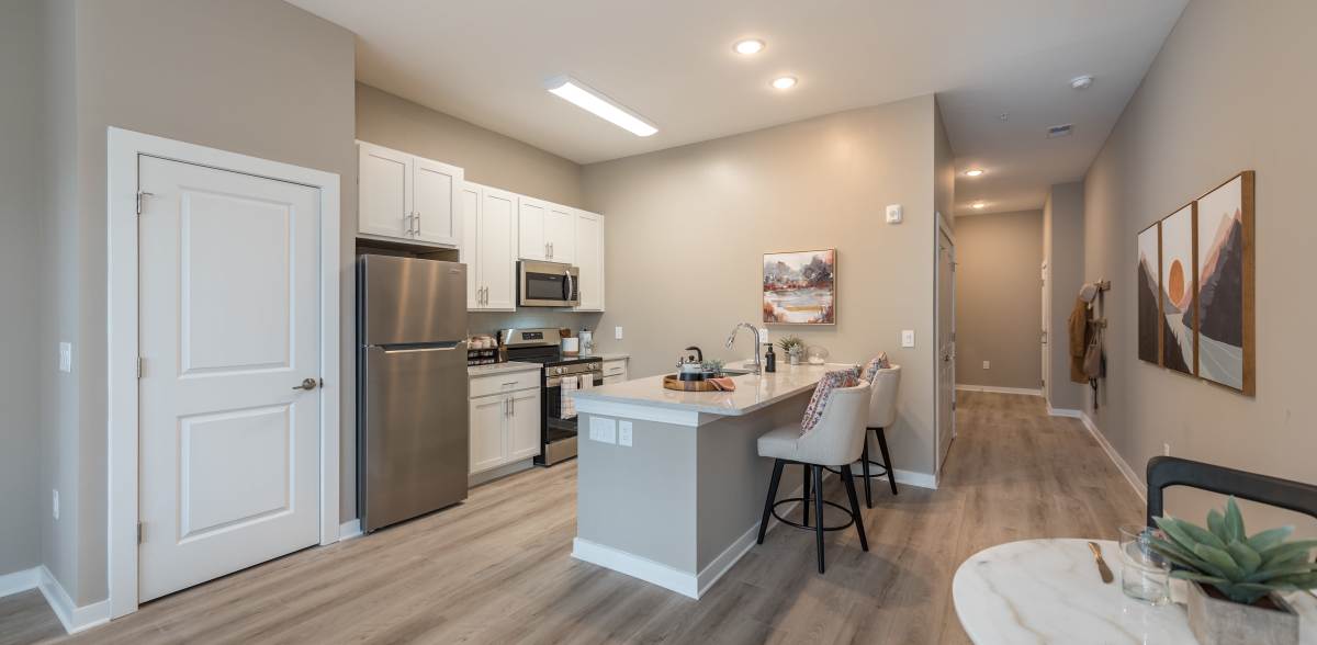 Spacious living room adjacent to the kitchen at Acclaim at Cary Pointe in Cary, North Carolina