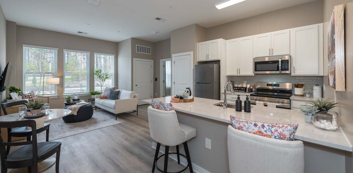Dining table on the kitchen counter with spacious living room at Acclaim at Cary Pointe in Cary, North Carolina