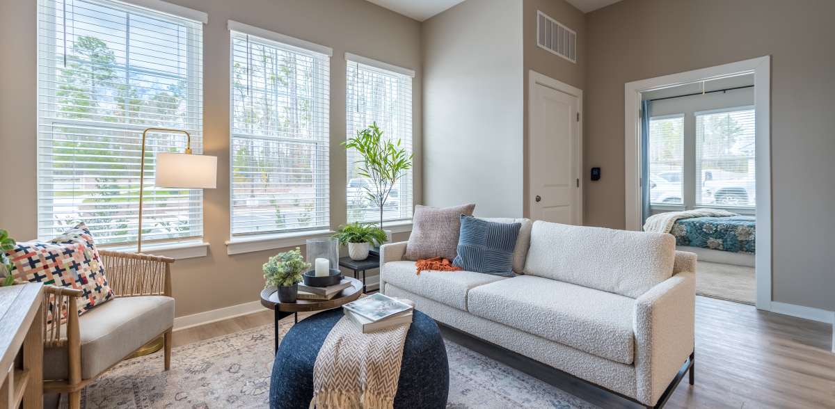 Living room with big windows, spacious couch and coffee table at Acclaim at Cary Pointe in Cary, North Carolina