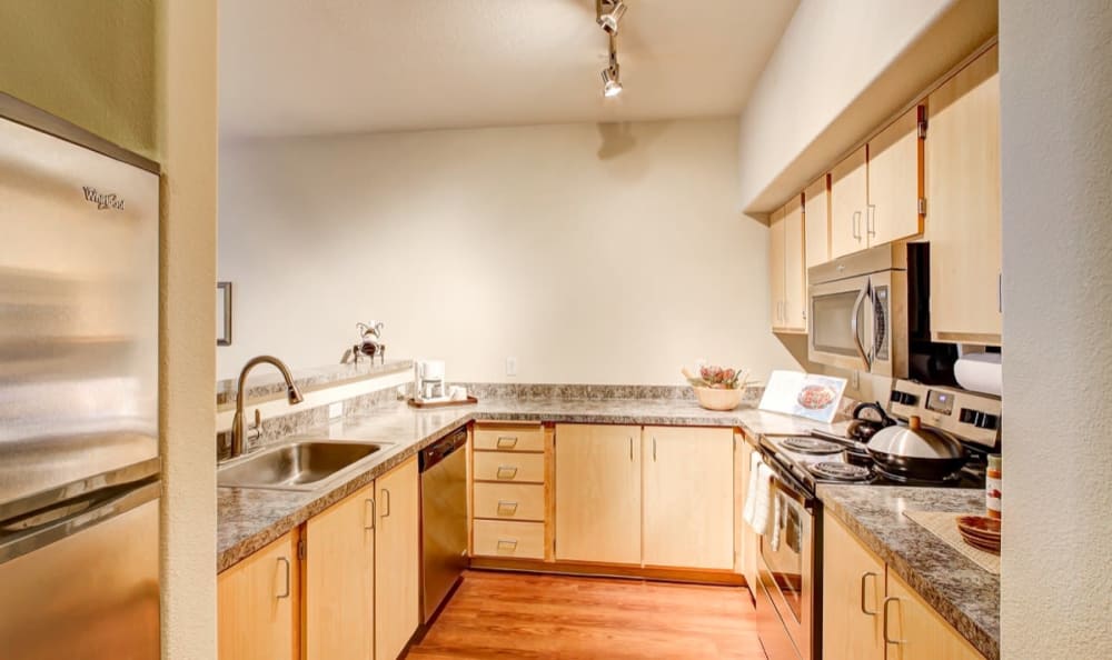 Gourmet kitchen with granite countertops and stainless-steel appliances in a model home at Columbia Trails in Gresham, Oregon
