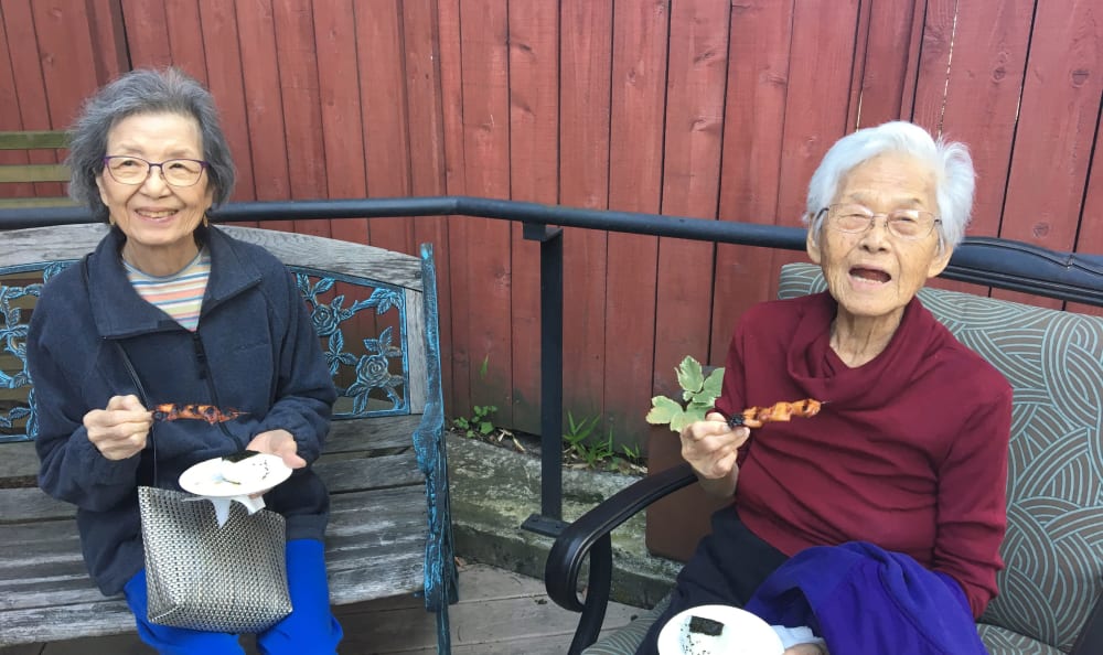 Two residents sitting outside at Nikkei Manor in Seattle, WA