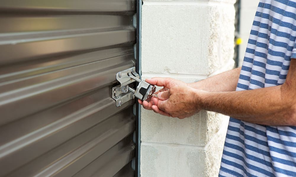 Man putting a padlock to his self storage unit at Armadillo Self Storage South in High Point, NC