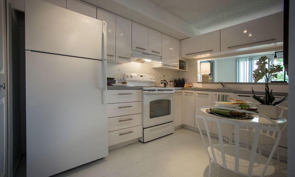 Modern eat-in kitchen with white cabinetry and white appliances at Briar Cove Terrace Apartments in Ann Arbor, Michigan