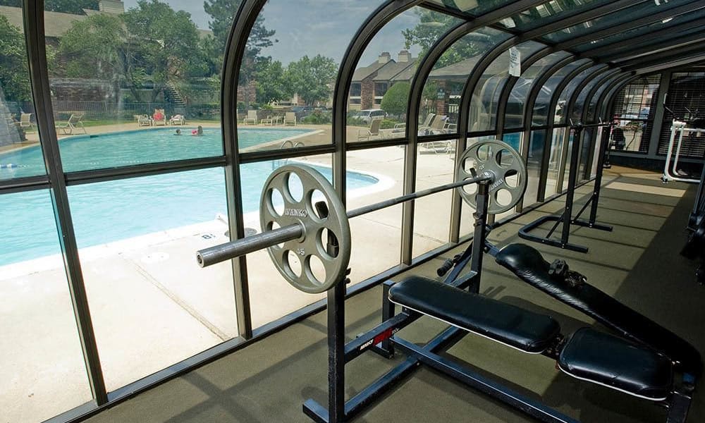A community gym with a view of the pool at The Warrington Apartments in Oklahoma City, OK