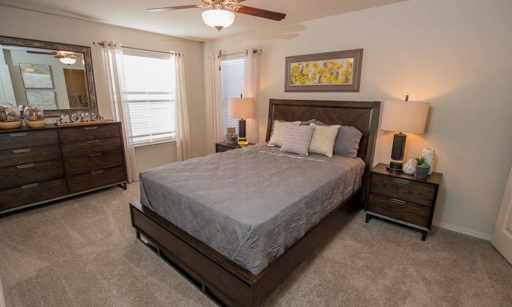 Primary bedroom with a ceiling fan at Cottages at Tallgrass Point Apartments in Owasso, Oklahoma