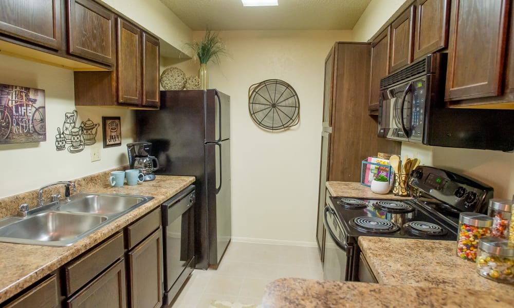 Modern kitchen with black appliances at Sugarberry Apartments in Tulsa, Oklahoma