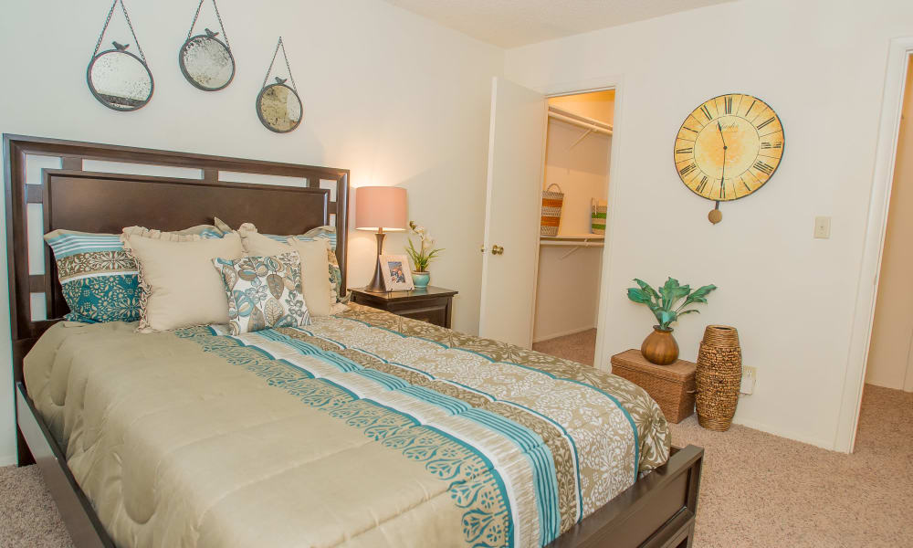 Master bedroom with en suite bathroom in model home at Sugarberry Apartments in Tulsa, Oklahoma