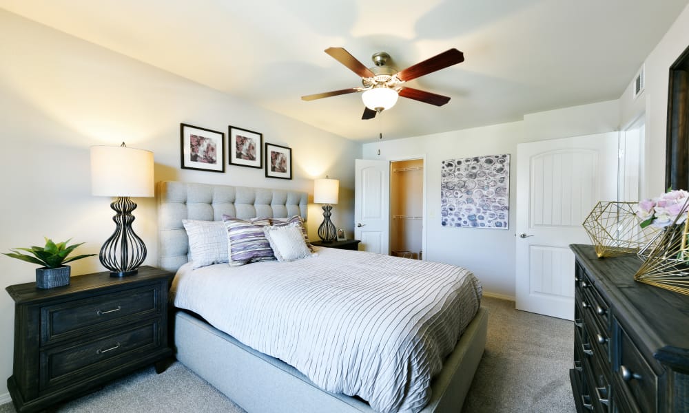 Primary bedroom with ceiling fan at Cottages at Abbey Glen Apartments in Lubbock, Texas