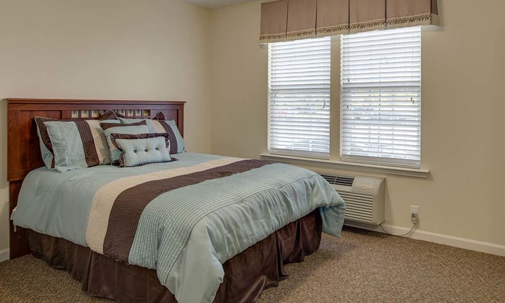 Studio apartment with a bed and seating area at Chestnut Glen Senior Living in Saint Peters, Missouri