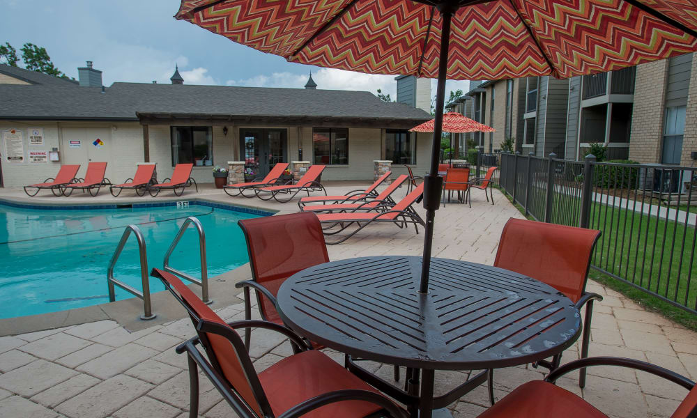 A table and chairs near the pool at Cimarron Pointe Apartments in Oklahoma City, OK