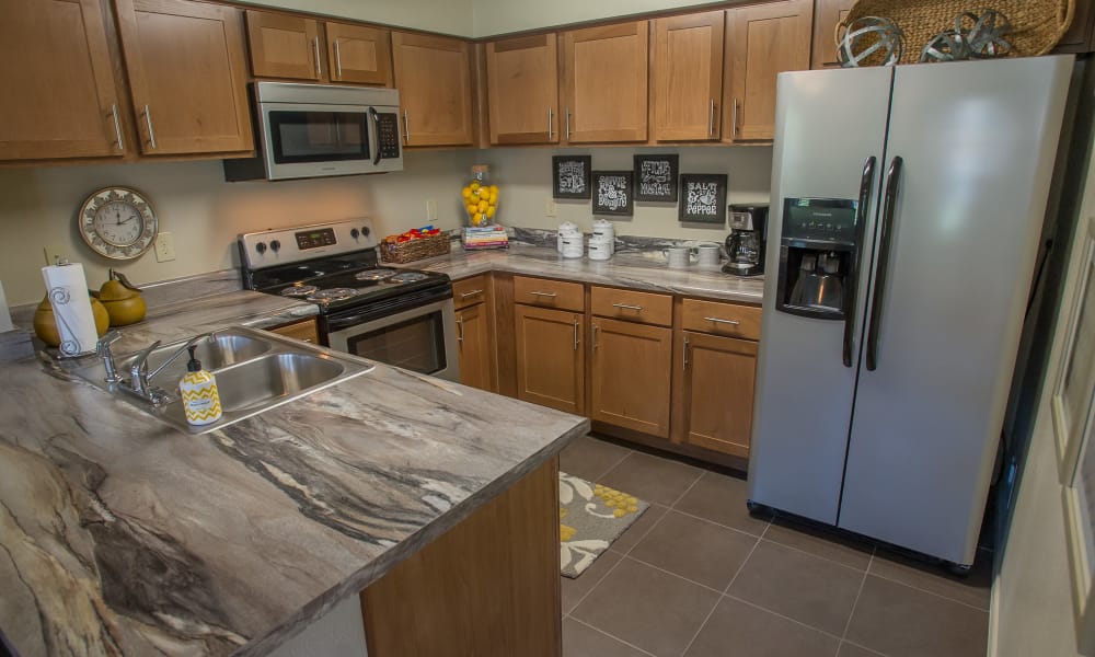 Bright kitchen with granite counters at The Reserve at Elm in Jenks, Oklahoma