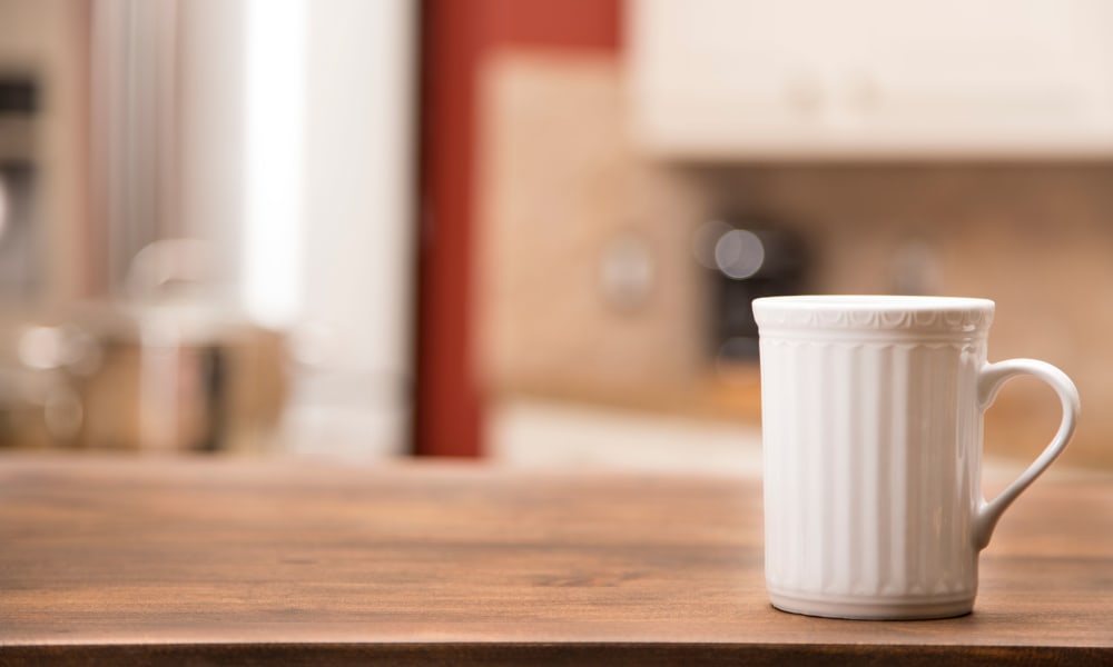 A white coffee mug on a wooden table at Waverly House in Bethesda, Maryland